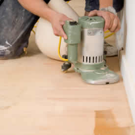 Sanding hardwood floors.